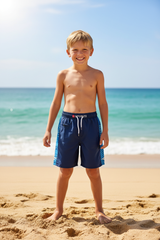 Boy on beach wearing Konexpro navy blue sports swim shorts